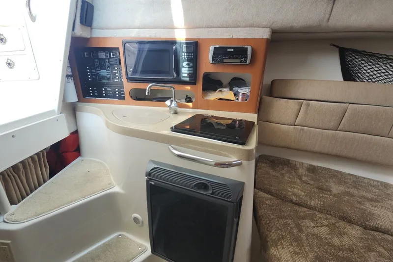 Slide: The Image of 2005 Seaswirl Striper 2901 Walkaround O/B cabin interior with kitchenette and seating area. - 19