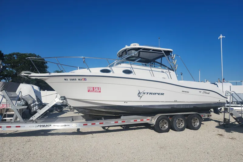 The Image of 2005 Seaswirl Striper 2901 Walkaround O/B boat on trailer, for sale under clear blue sky. - 0