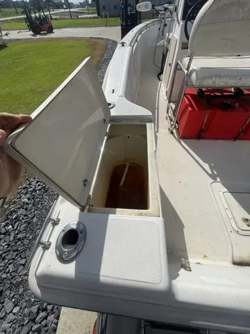 Slide: The Image of An open storage compartment on a 1997 Scout 185 Sportfish boat, with a red container nearby. - 27
