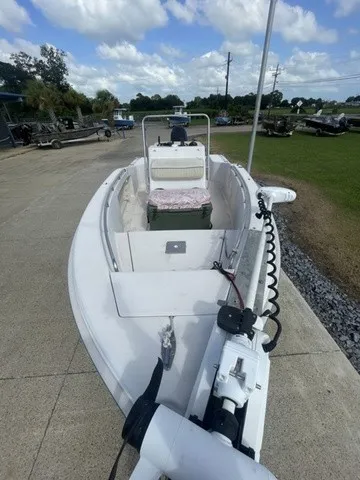 Slide: The Image of A 1997 Scout 185 Sportfish boat on a paved area. It features an open deck and a helm console. - 21