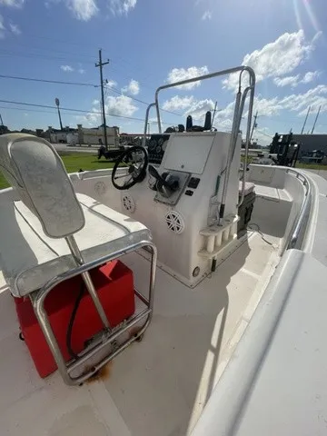 Slide: The Image of A 1997 Scout 185 Sportfish with a helm console and seating, under a blue sky. - 30