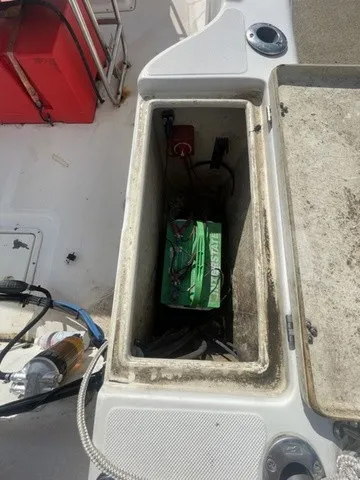 Slide: The Image of An open storage compartment on a 1997 Scout 185 Sportfish boat reveals a battery and wiring. - 28