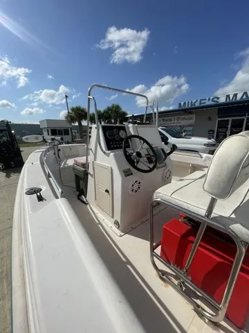 Slide: The Image of A 1997 Scout 185 Sportfish with a helm and seating area, outdoors in sunny weather. - 26