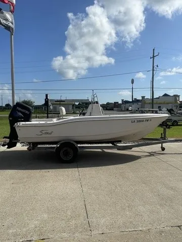 Slide: The Image of A 1997 Scout 185 Sportfish boat on a trailer in a parking lot. - 19