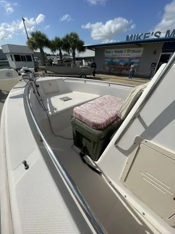 Slide: The Image of A 1997 Scout 185 Sportfish with an open cabin and seat cushion, parked in front of a building. - 32