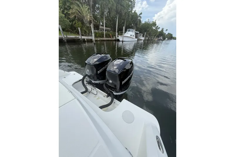 Slide: The Image of Boston Whaler 330 Outrage 2016 with twin Mercury outboard engines on a calm waterway. - 30