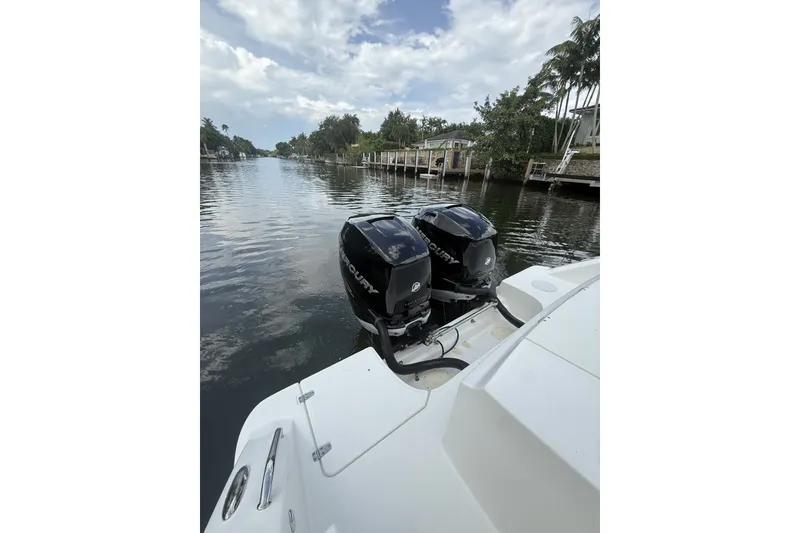 Slide: The Image of Boston Whaler 330 Outrage 2016 with dual Mercury engines on a calm waterway. - 32