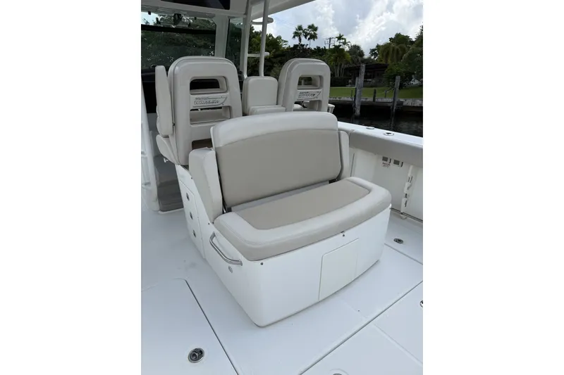 Slide: The Image of 2016 Boston Whaler 330 Outrage boat seating area with cushioned seats and storage. - 24