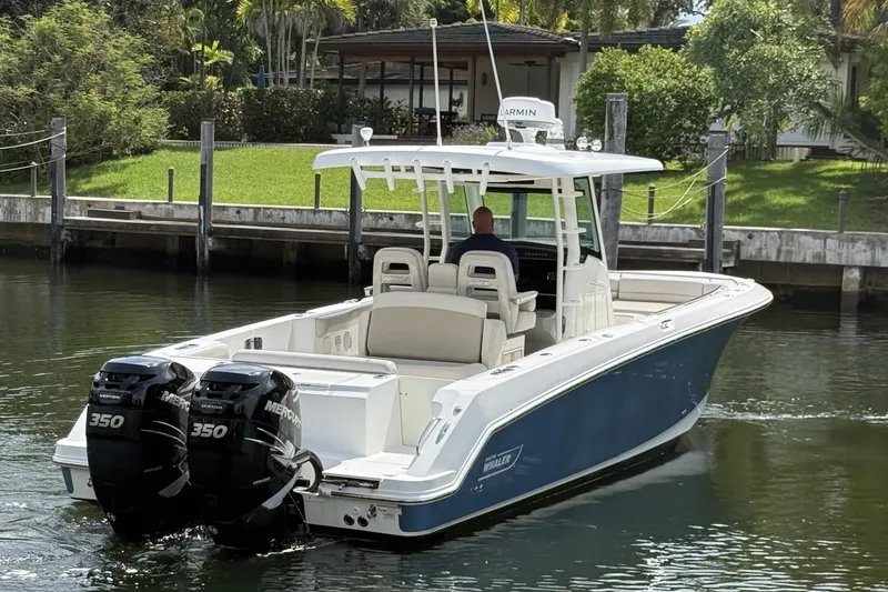 Slide: The Image of 2016 Boston Whaler 330 Outrage boat with dual Mercury 350 engines on a calm waterway. - 7