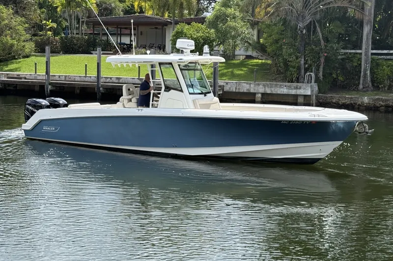 Slide: The Image of 2016 Boston Whaler 330 Outrage boat cruising on a calm waterway near lush greenery. - 9