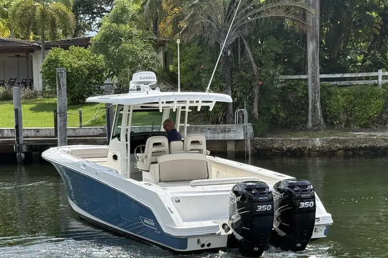 Slide: The Image of 2016 Boston Whaler 330 Outrage boat with twin Mercury 350 engines on a calm waterway. - 5