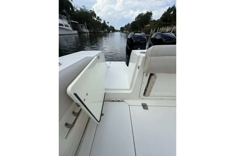 Slide: The Image of 2016 Boston Whaler 330 Outrage boat interior with open hatch, docked by a canal. - 20