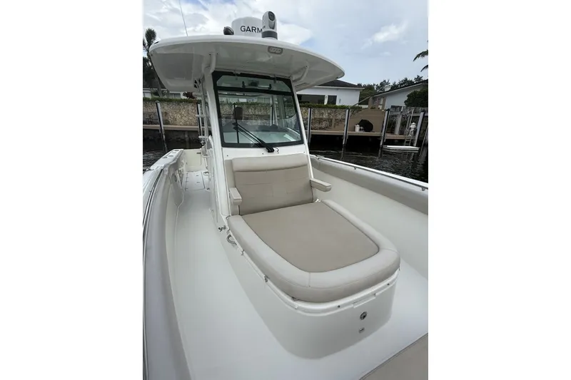 Slide: The Image of 2016 Boston Whaler 330 Outrage boat with cushioned seating and Garmin equipment. - 14