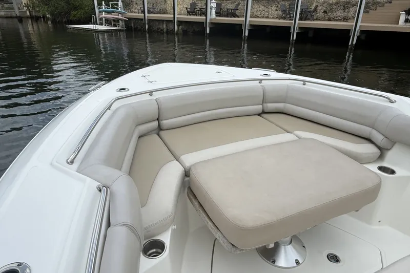 Slide: The Image of 2016 Boston Whaler 330 Outrage boat with cushioned seating area near dock. - 11