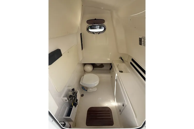 Slide: The Image of 2016 Boston Whaler 330 Outrage cabin interior with toilet and sink. - 33