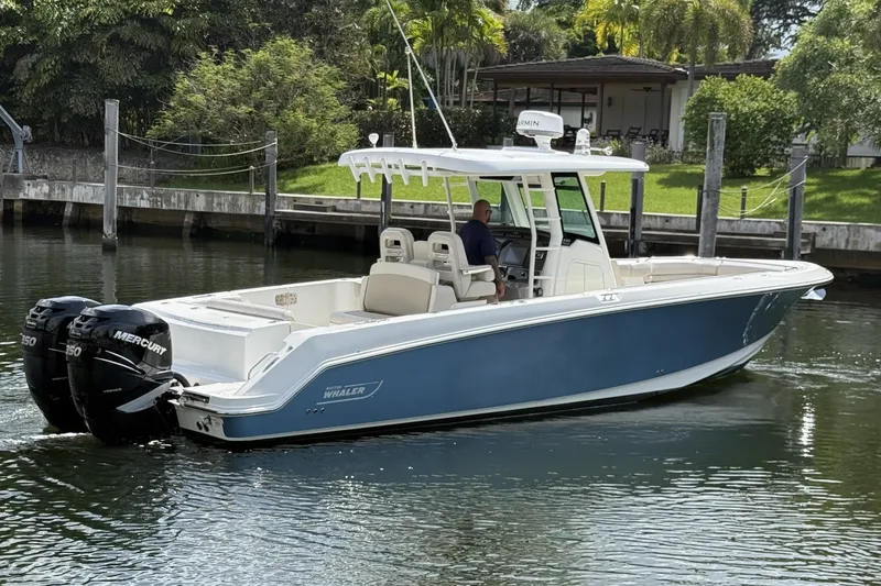Slide: The Image of 2016 Boston Whaler 330 Outrage boat with twin Mercury engines on a calm waterway. - 8
