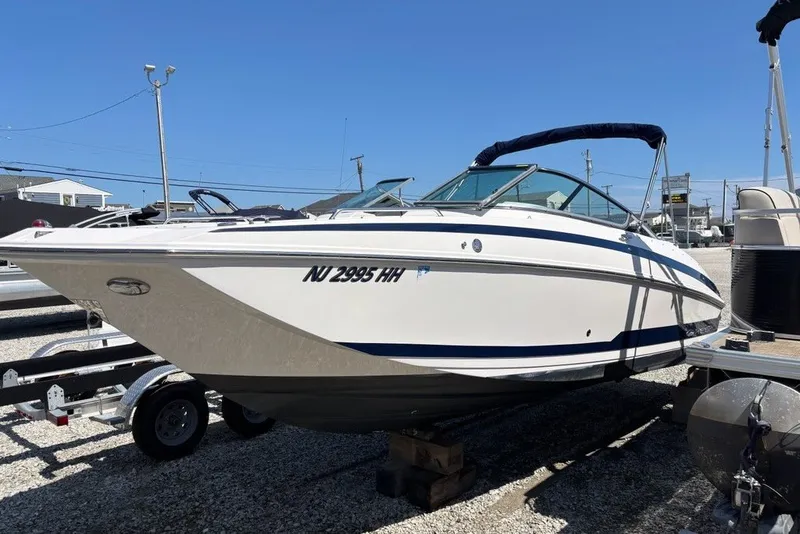 The Image of 2016 Regal 24 FasDeck boat on trailer, parked outdoors under clear blue sky. - 0