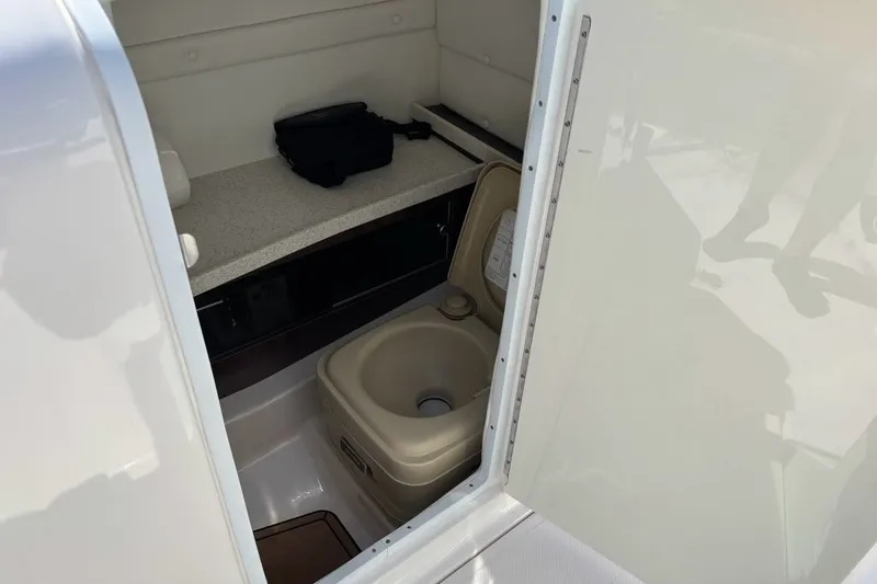 Slide: The Image of 2016 Regal 24 FasDeck boat interior with portable toilet and storage area. - 8