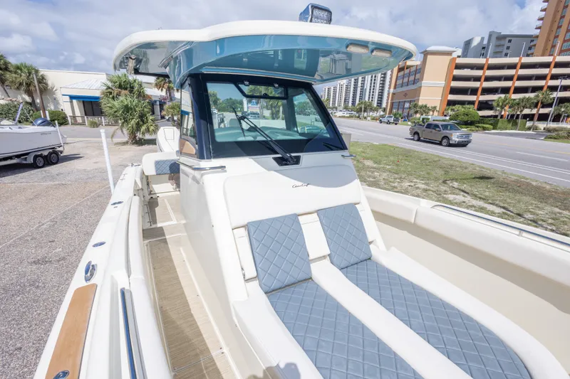 Slide: The Image of 2023 Chris-Craft Catalina 30 boat with blue seating, parked near a road. - 44