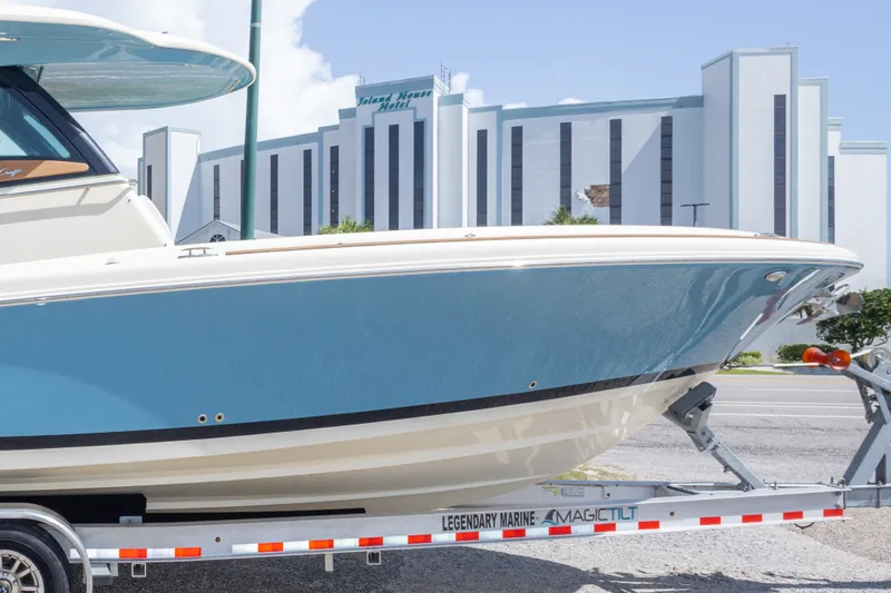 Slide: The Image of 2023 Chris-Craft Catalina 30 boat on trailer, with modern building in background. - 24