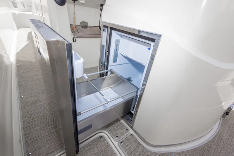 Slide: The Image of Open refrigerator drawer on 2023 Chris-Craft Catalina 30 boat, showcasing interior storage space. - 58
