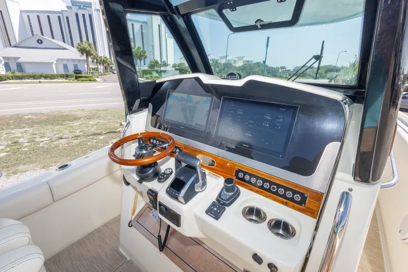 Slide: The Image of 2023 Chris-Craft Catalina 30 helm with modern controls and wooden steering wheel. - 31