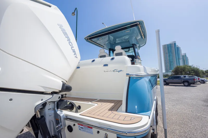 Slide: The Image of 2023 Chris-Craft Catalina 30 boat with Mercury engine, parked near modern buildings. - 12