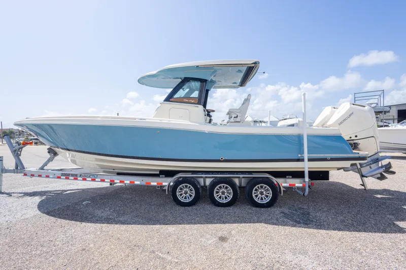 Slide: The Image of 2023 Chris-Craft Catalina 30 boat on trailer, blue hull, parked outdoors. - 15