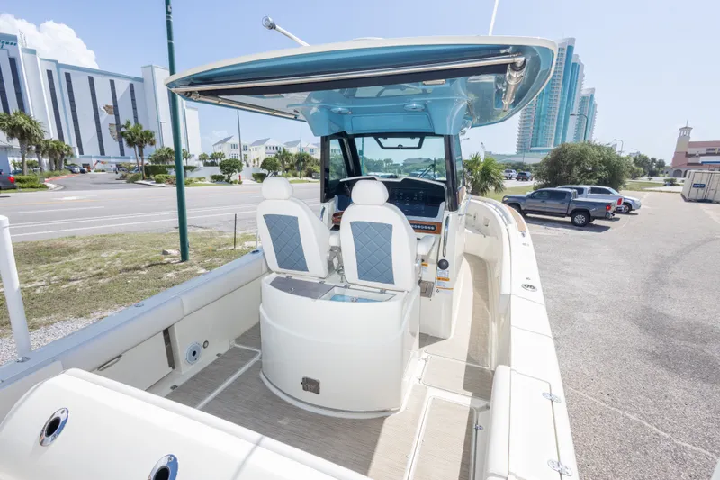 Slide: The Image of 2023 Chris-Craft Catalina 30 boat interior with modern seating and dashboard, parked near buildings. - 26