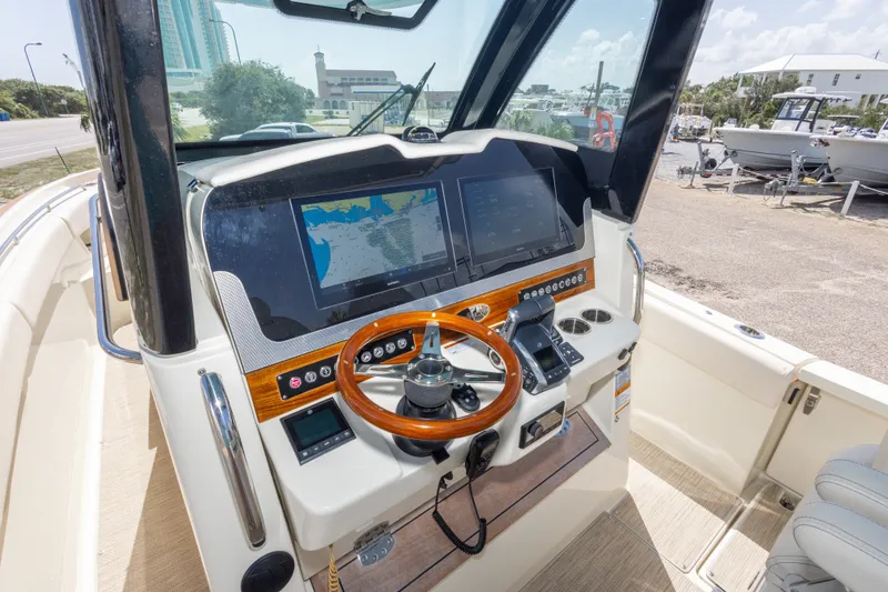 Slide: The Image of 2023 Chris-Craft Catalina 30 helm with modern navigation system and wooden steering wheel. - 32