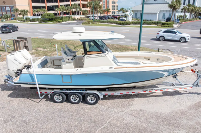 Slide: The Image of 2023 Chris-Craft Catalina 30 boat on trailer, parked near a road. - 2