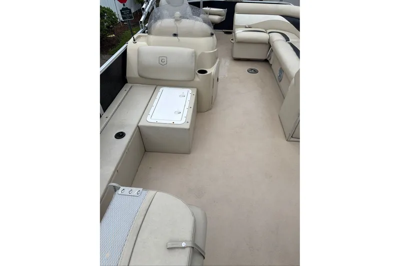Slide: The Image of 2016 Godfrey Sweetwater 2286 pontoon boat interior with beige seating and helm. - 10