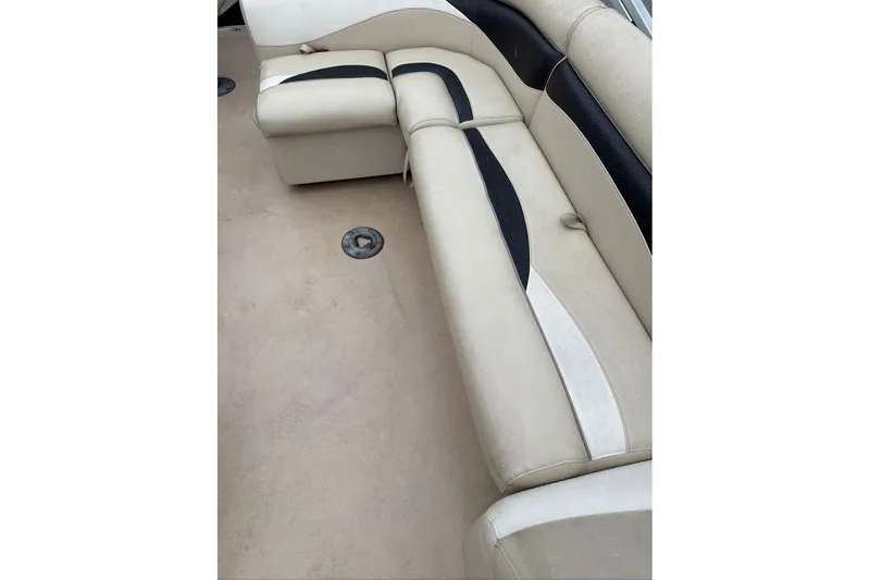 Slide: The Image of Interior seating of a 2016 Godfrey Sweetwater 2286 pontoon boat, featuring beige and black upholstery. - 11