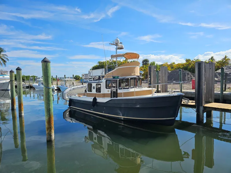 The Image of A 2014 Ranger Tugs 31-CB docked in a harbor on a sunny day. - 0