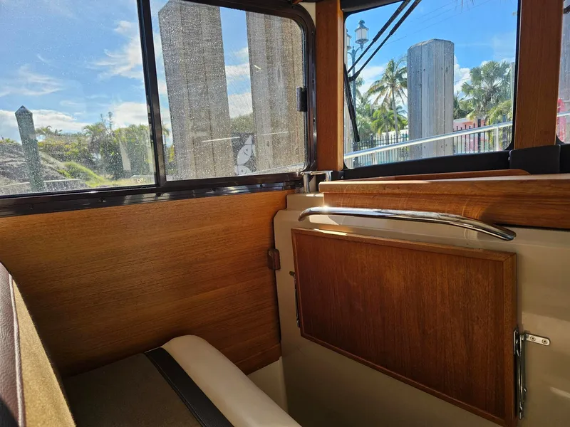 Slide: The Image of Interior of a 2014 Ranger Tugs 31-CB with wood paneling and windows offering an outdoor view. - 30
