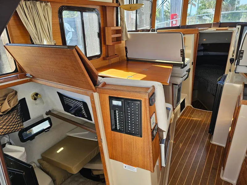 Slide: The Image of Interior of a 2014 Ranger Tugs 31-CB with wood paneling and cozy seating areas. - 25