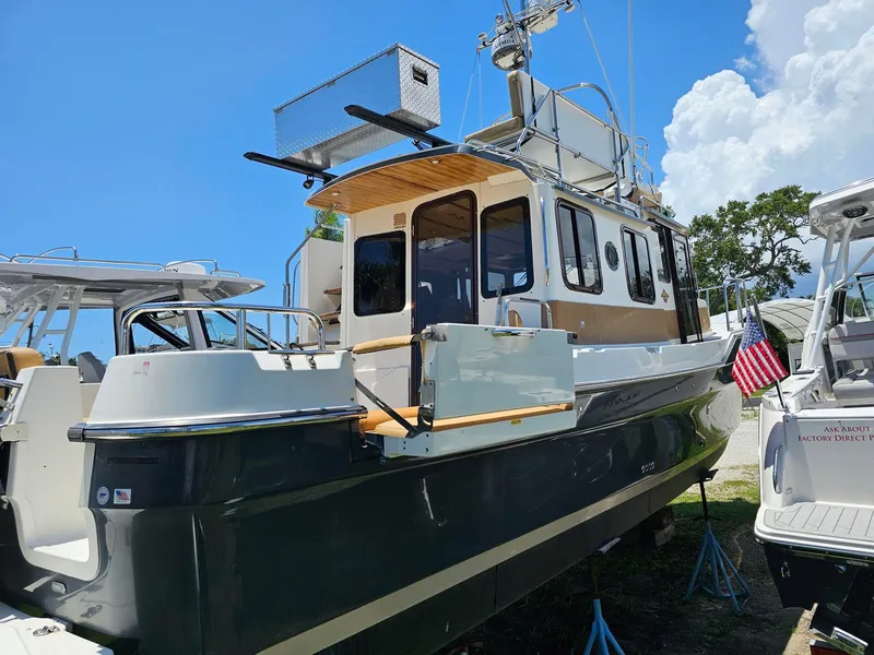 Slide: The Image of A 2014 Ranger Tugs 31-CB with a dark blue hull and wood accents, propped up on land. - 5