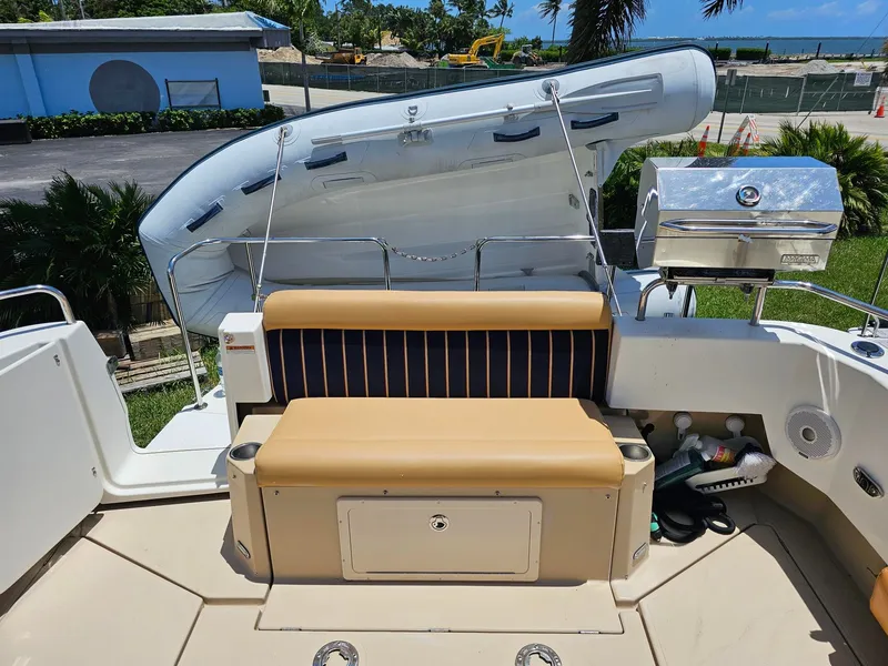 Slide: The Image of The image shows the stern of a 2014 Ranger Tugs 31-CB with a cushioned bench and a grill. - 22