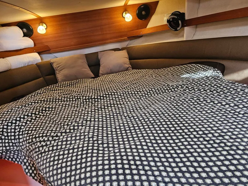 Slide: The Image of The cabin of the 2014 Ranger Tugs 31-CB features a cozy bed with a patterned cover. - 35