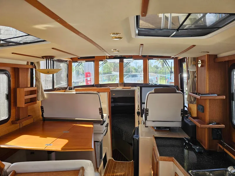 Slide: The Image of Interior of a 2014 Ranger Tugs 31-CB with wooden furnishings and large windows. - 27