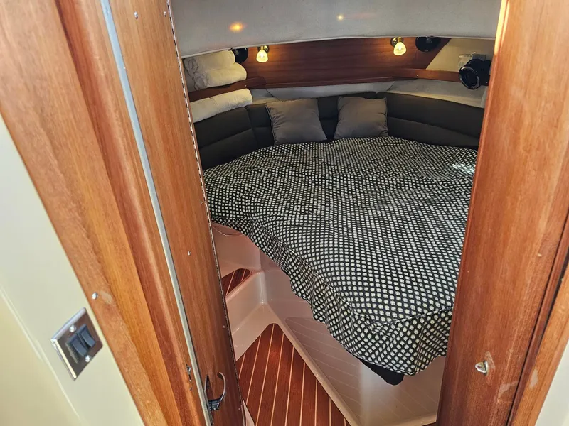 Slide: The Image of The cabin of a 2014 Ranger Tugs 31-CB with a cozy bed and wooden accents. - 34