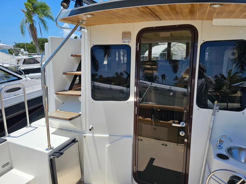 Slide: The Image of The 2014 Ranger Tugs 31-CB features an exterior staircase and a glass door leading to the cabin. - 20