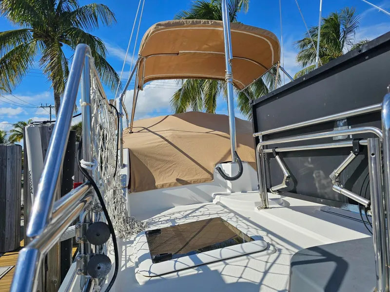 Slide: The Image of The image shows the deck of a 2014 Ranger Tugs 31-CB with sunshade and palm trees in the background. - 16