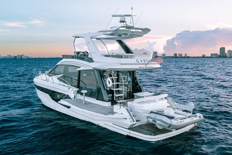 Slide: The Image of 2021 Galeon 500 Fly yacht cruising at sunset near city skyline. - 4