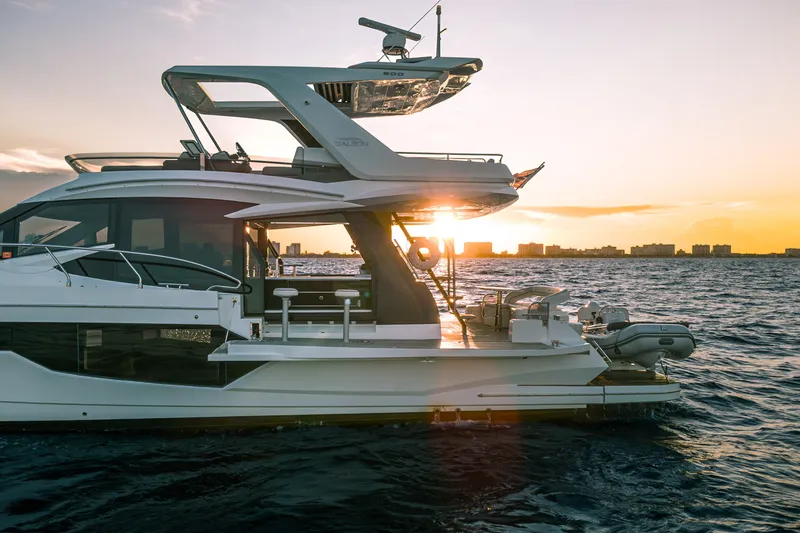 Slide: The Image of 2021 Galeon 500 Fly yacht at sunset on the ocean, showcasing sleek design and luxury. - 5