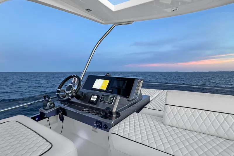 Slide: The Image of 2021 Galeon 500 Fly yacht helm with luxurious seating and ocean view at sunset. - 22