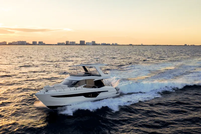 Slide: The Image of 2021 Galeon 500 Fly yacht cruising at sunset near city skyline. - 36