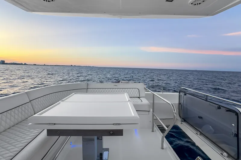 Slide: The Image of Luxury 2021 Galeon 500 Fly yacht deck at sunset, featuring elegant seating and ocean view. - 21