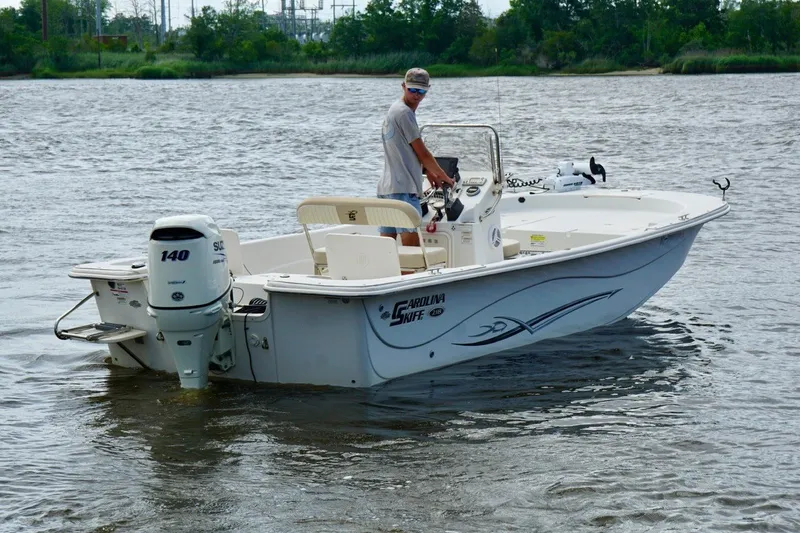 Slide: The Image of 2017 Carolina Skiff 218 DLV boat on water, featuring Suzuki 140 outboard motor. - 5
