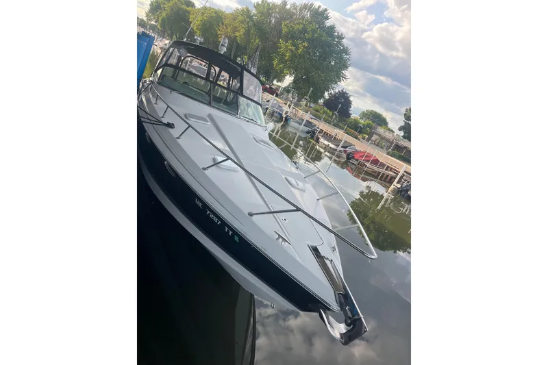 Slide: The Image of 2006 Formula 370 Super Sport boat docked on a calm lake under a cloudy sky. - 1